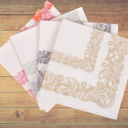 CrossWave Ecopacks white paper napkins with ornate gold, pink, and grey floral border designs, 23x23cm.